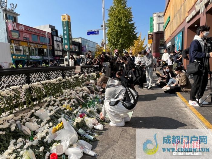 当地时间2022年10月31日，韩国首尔市龙山区梨泰院站1号口，汉密尔顿酒店楼下，民众送来鲜花和祭品悼念遇难者。29日晚间，首尔市龙山区梨泰院发生严重踩踏事故，截至当地时间31日6时，首尔踩踏事故已造成154人遇难，149人受伤，其中33人重伤，116人轻伤。<a target='_blank' href='/'>中新社</a>记者 刘旭 摄