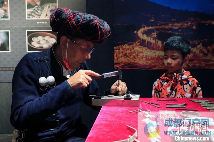 彝族银饰制作技艺国家级非遗传承人勒古沙日正在打制银器。　王磊 摄 摄